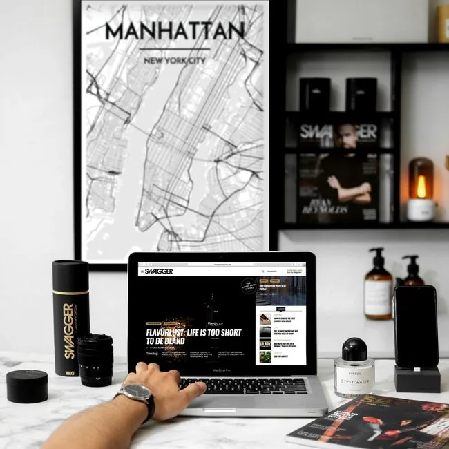 Un uomo sfoglia le pagine di un portfolio di design su un tavolo in legno, in stile moderno.